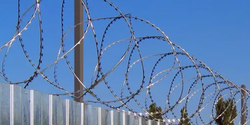 Mounting razor wire on a fence